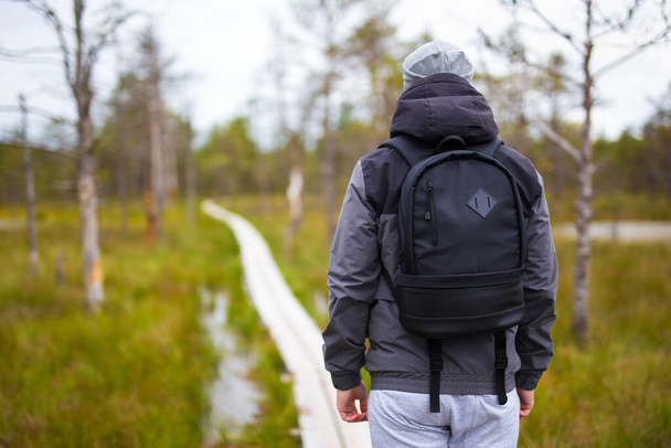 travel concept - rear view of man hiking in forest - Photo, Image