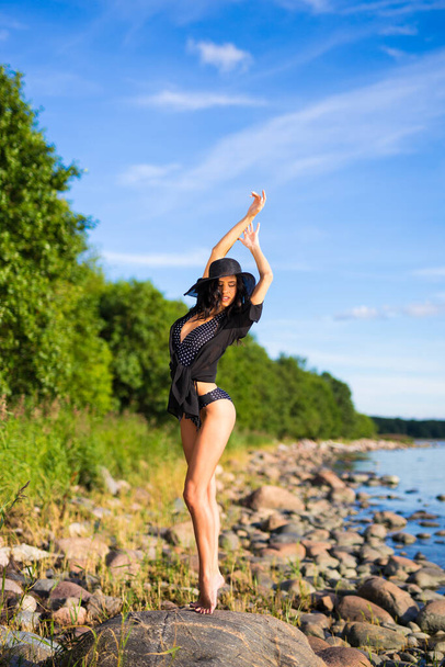 summer and vacation concept - full length portrait of beautiful model in bikini posing on rocky beach - Foto, Bild