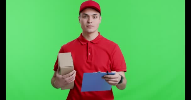 Friendly courier with parcel giving notepad to camera a - Footage, Video