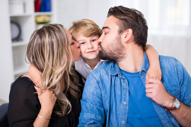 happy family portrait - young couple kissing little son - Фото, изображение