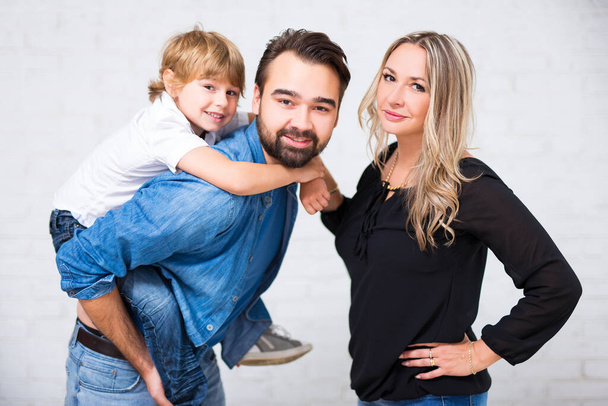 щасливий сімейний портрет - пара з милим маленьким сином позує на білому
 - Фото, зображення