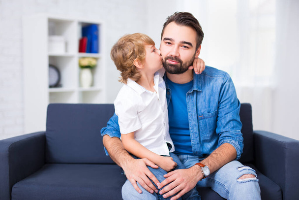 家族と愛の概念-小さな息子が家で父親とキスをする - 写真・画像