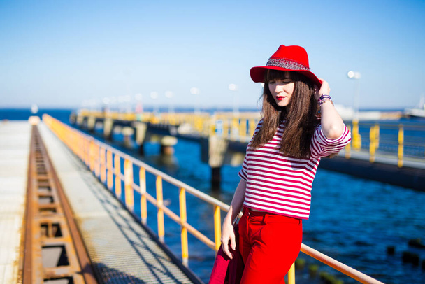 portrait of young woman in red clothes posing on the pier - Fotografie, Obrázek