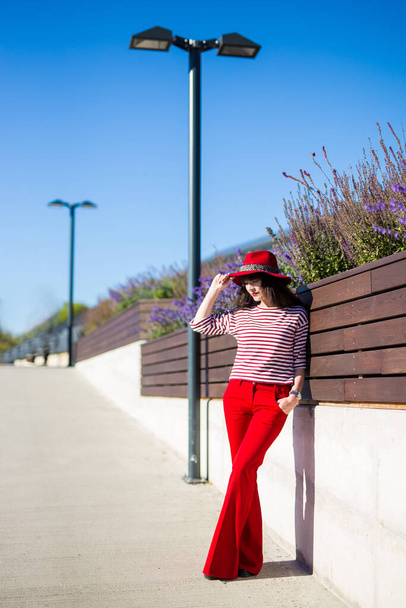 Sokakta poz veren kırmızı elbiseli güzel bir kadının portresi. - Fotoğraf, Görsel