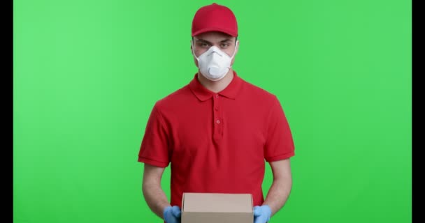 Mensajero en máscara protectora y guantes ofreciendo paquete
 - Imágenes, Vídeo