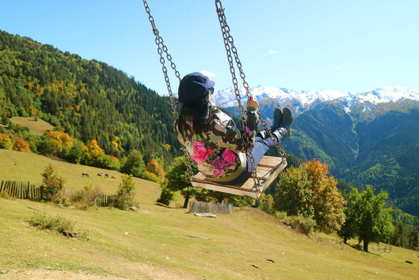 Woman Enjoy the Swing com uma vista panorâmica incrível da montanha do Cáucaso em Mestia, região de Svaneti, Geórgia
 - Foto, Imagem