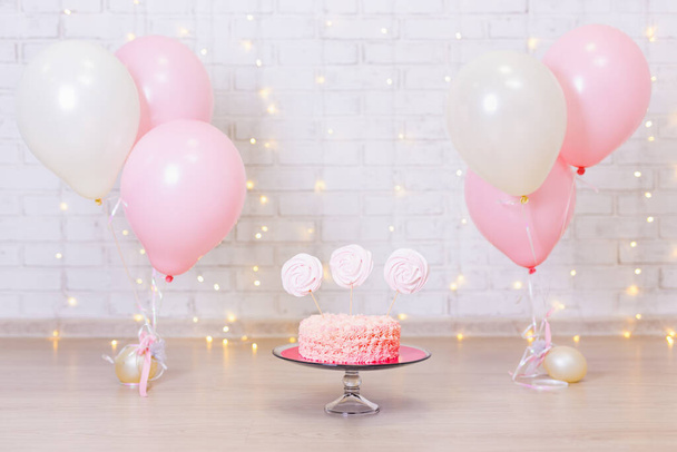 birthday celebration concept - cake over brick wall background with lights and colorful balloons - Fotoğraf, Görsel
