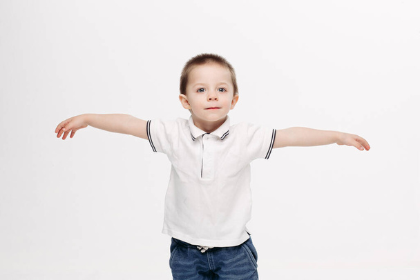 Little boy playing and showing wings like flying bird. - Fotó, kép