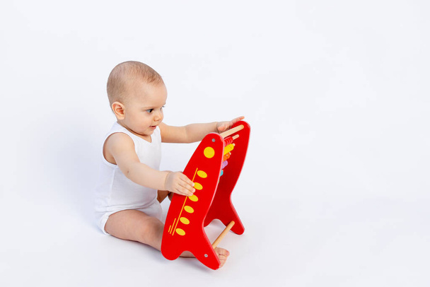 child playing with bills on a white background, early development, up to a year, space for text - Foto, afbeelding