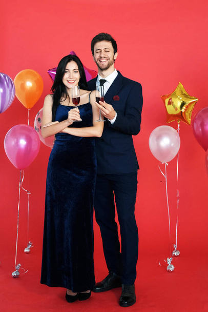 Sweet couple Love smile and spending Romantic with drinking wine in christmas time and celebrating new year eve, valentine day with colorful balloon on red background - Fotoğraf, Görsel