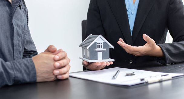 Agent nieruchomości lub kierownik sprzedaży zaoferował sprzedaż domu i wyjaśnił warunki podpisania umowy kupna domu i bezpłatnego ubezpieczenia domu, Finansów i usług posprzedażnych koncepcji - Zdjęcie, obraz