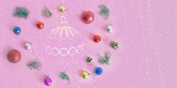 Christmas balls, cones and twigs of juniper on pink background;  bright festoon illumination - double exposure . Flat lay, copy space - Photo, Image