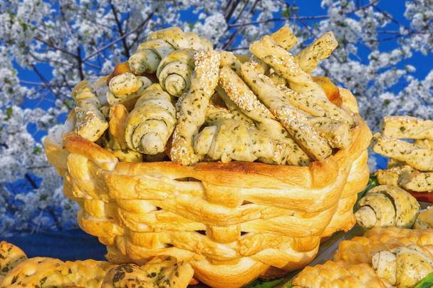 Mand met gebak op tafel tegen blauwe lucht en boom in bloei - Foto, afbeelding