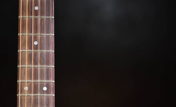 Guitar neck and strings close up on a black background - Photo, Image