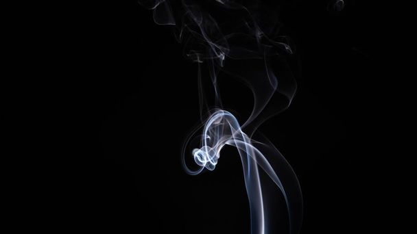 A white smoke creating abstract shapes on a black background - Fotó, kép