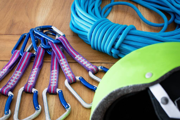 A closeup shot of rock climbing equipment under the light: ropes, quickdraws, helmet - Фото, изображение
