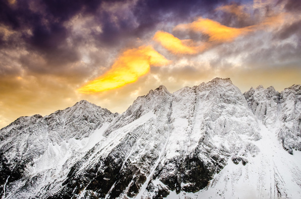 Montagne invernali con drammatico cielo colorato al tramonto
 - Foto, immagini