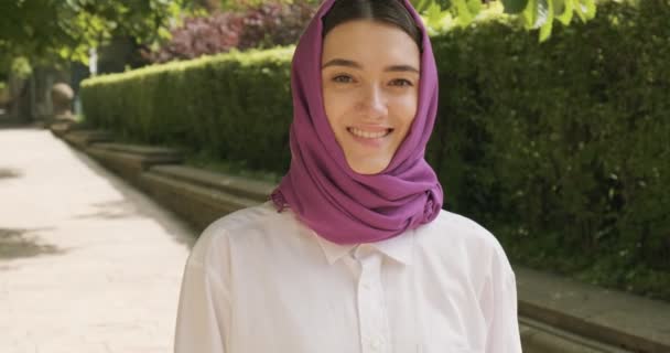 Beautiful young woman looking at camera, wearing traditional headscarf. Attractive Female in hijab - Footage, Video