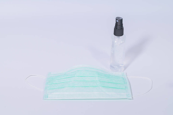 Hygienemaske mit Alkohol-Gel zum Händewaschen Verhindert Coronavirus oder Covic-19-Erreger. Weiße Hintergrundszene - Foto, Bild