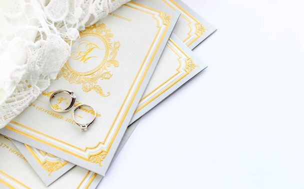  кольцо на свадебной открытке с мягким фокусом и над светом в фоновом режиме
 - Фото, изображение