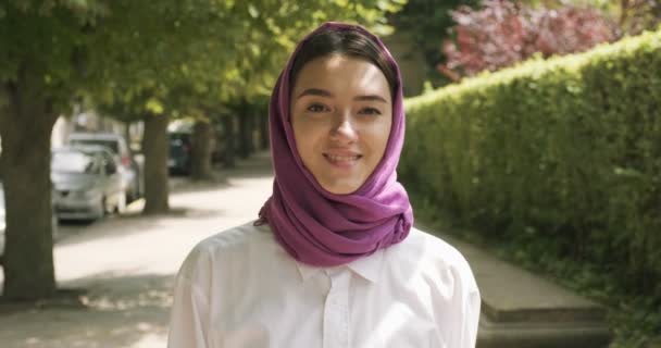 Schöne junge Frau läuft auf der Straße und trägt ein traditionelles Kopftuch. Attraktive Frau im Hidschab - Filmmaterial, Video