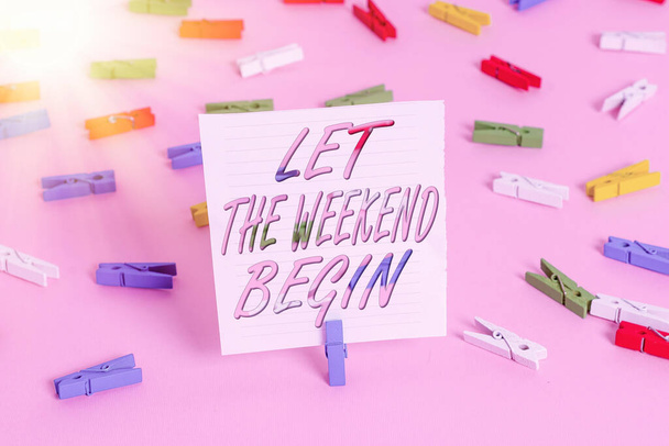 Написание текста "Пусть начнутся выходные". Business concept for happy Saturday Welcome Holiday Let ts enjoy the day Colored clothespin papers empty reminder pink floor background office pin
. - Фото, изображение