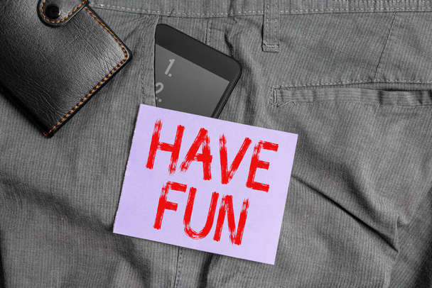 Piszę liścik z "Miłej zabawy". Business photo showcasing robi zadanie, które zapewnia sobie przyjemność i rozrywkę Smartphone urządzenie wewnątrz spodni przednia kieszeń z portfelem. - Zdjęcie, obraz