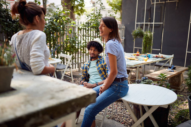 Young man enjoys girls company at cafe's garden - Fotografie, Obrázek