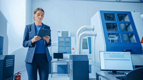 " Modern Factory: Confident Female Engineer Walks Through Facility, Holding Laptop, Inspecting and Monitoring Workshop Workings. Manufactory Has Professionals Working on CNC Machinery, Robot Arm" - Foto, Imagem
