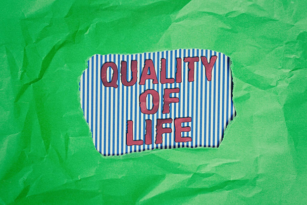 Koncepcionális kézírás az Életminőség bemutatásával. Üzleti fotó bemutató Család Emberek Érzések Kifejezés, kényelem és boldogság Zöld gyűrött színes papír lap szakadt színes háttér. - Fotó, kép