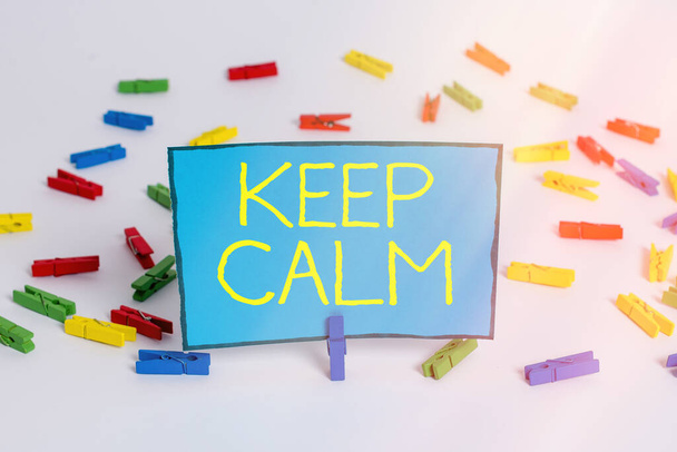 Word writing text Keep Calm. Business concept for remain composure over situations with fewer emotions involved Colored clothespin papers empty reminder white floor background office. - Photo, Image