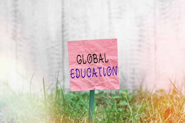 Conceptual hand writing showing Global Education. Business photo text interdisciplinary approach to learning concepts necessary Plain paper attached to stick and placed in the grassy land. - Photo, Image