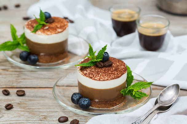 Домашний маленький мини-кофе и шоколадный чизкейк с черникой и мятными листьями на тарелке
  - Фото, изображение
