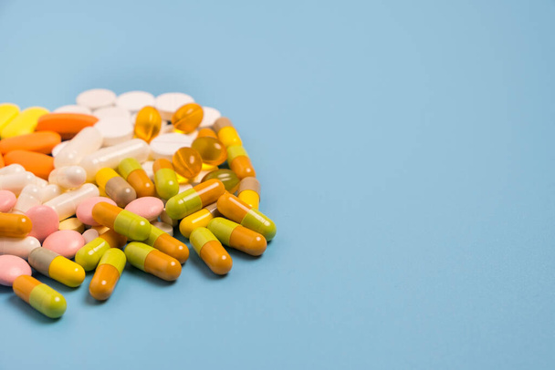 Close up of many different pills on blue background. - Foto, Imagem