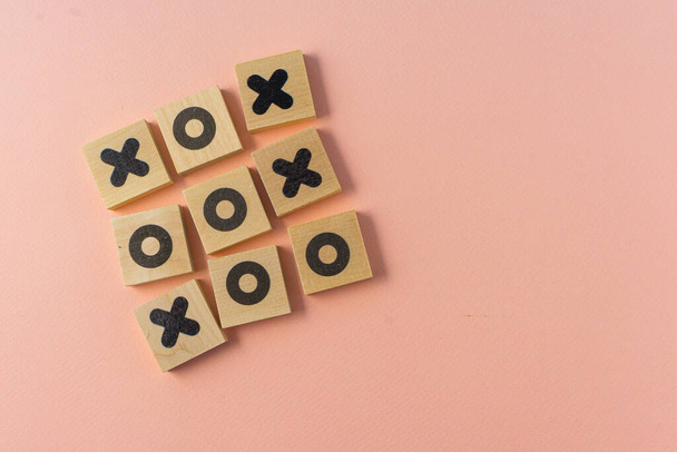 selective focus, wooden dice game TIC-TAC-toe on a paper colored background, copyspace - 写真・画像