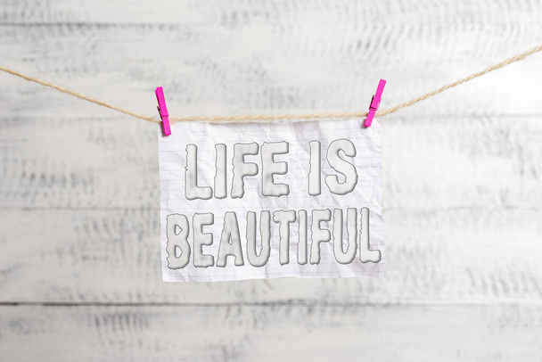 Handwriting text writing Life Is Beautiful. Concept meaning Go to adventure vacation, enjoy and relax to satisfy nature every moment Clothesline clothespin rectangle shaped paper reminder white wood - Fotoğraf, Görsel