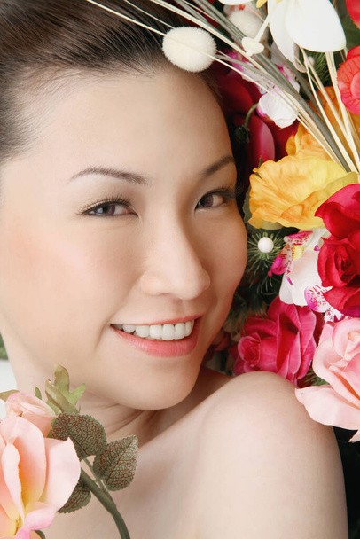 Woman posing beside floral background - Фото, изображение