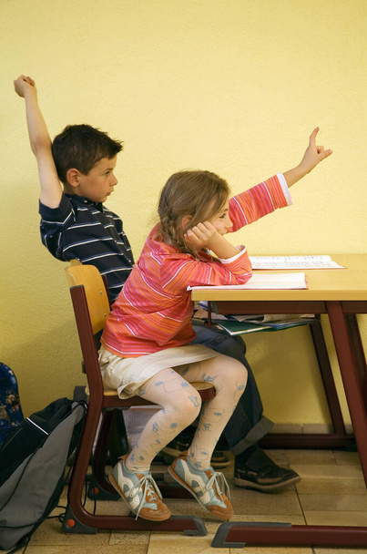 Children raising their hands to answer question - Fotoğraf, Görsel