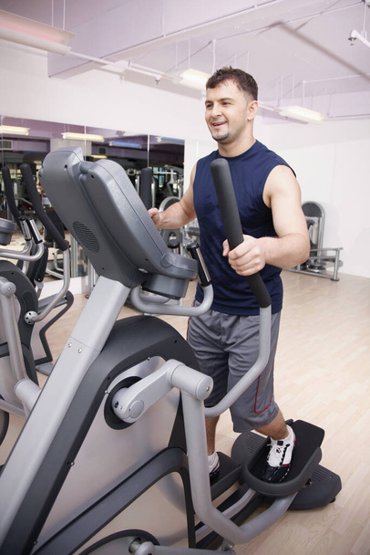 Man exercising on gym equipment - Photo, Image