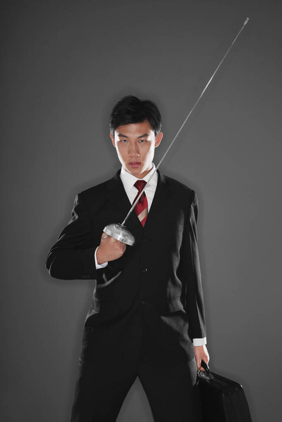 Businessman with a fencing foil - Foto, afbeelding