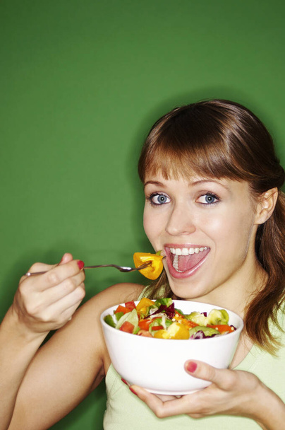 Woman enjoying a bowl of salad - Фото, изображение