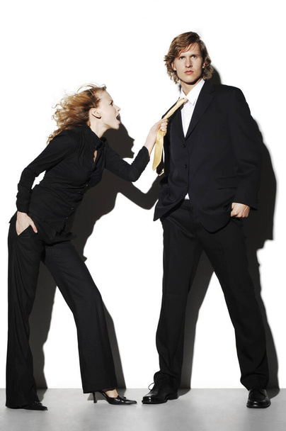 Businesswoman pulling a businessman's tie - Φωτογραφία, εικόνα
