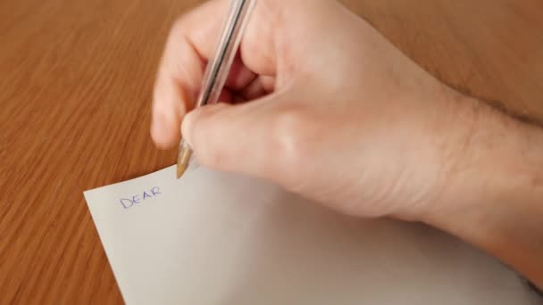 mężczyzna pisze list z przeprosinami długopisem i papierem - Materiał filmowy, wideo