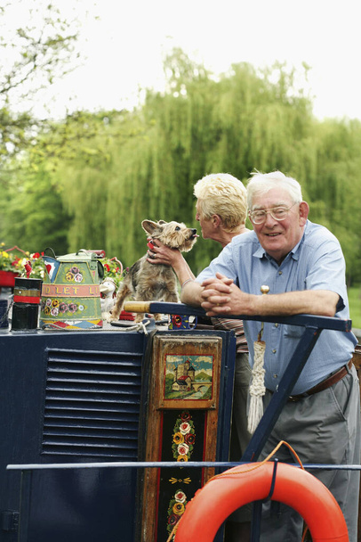 Senior couple and their pet dog on the houseboat - Foto, Imagen