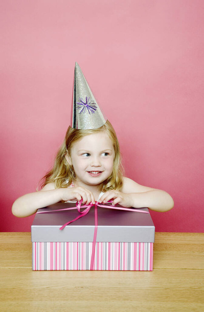 Girl unwrapping her present - 写真・画像