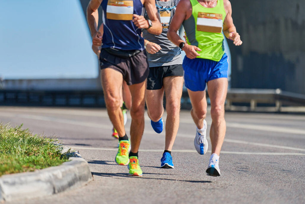 Marathon runners on city road. Running competition. Street sprinting outdoor. Healthy lifestyle, fitness sport event. - Photo, Image