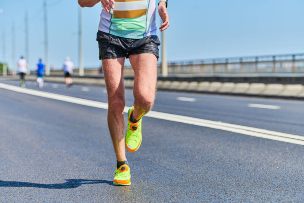 Běžící muž. Atletický muž běhá ve sportovním oblečení na městské silnici. Zdravý životní styl, sportovní koníček. Street maraton závod, sprint venkovní - Fotografie, Obrázek