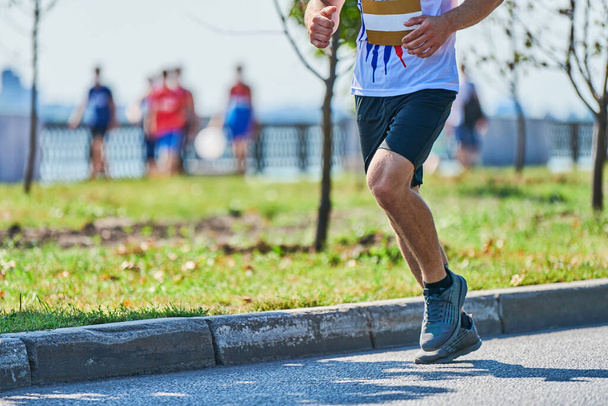 Un uomo in corsa. Uomo atletico che fa jogging in abbigliamento sportivo sulla strada cittadina. Stile di vita sano, sport fitness hobby. Allenamento in strada, sprint outdoor - Foto, immagini