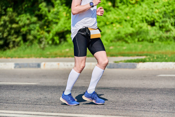 L'homme qui court. Homme athlétique jogging en vêtements de sport sur la route de la ville. Mode de vie sain, passe-temps sportif fitness. Entraînement de rue, sprint extérieur - Photo, image