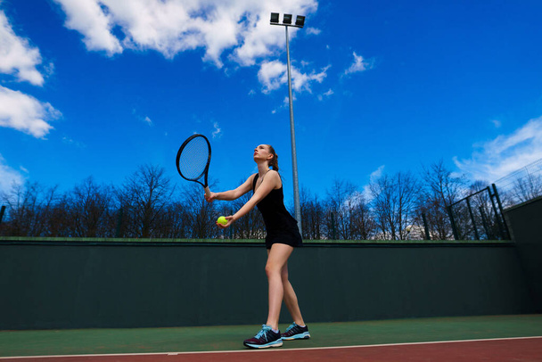 Sexy fille joueuse de tennis en robe blanche et talons tenant raquette de tennis sur le court. La jeune femme joue au tennis, au sport - Photo, image